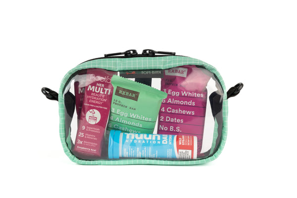 A Seafoam (green with white grid pattern) Halcyon 3D Clear Organizer Cube filled with sundries.